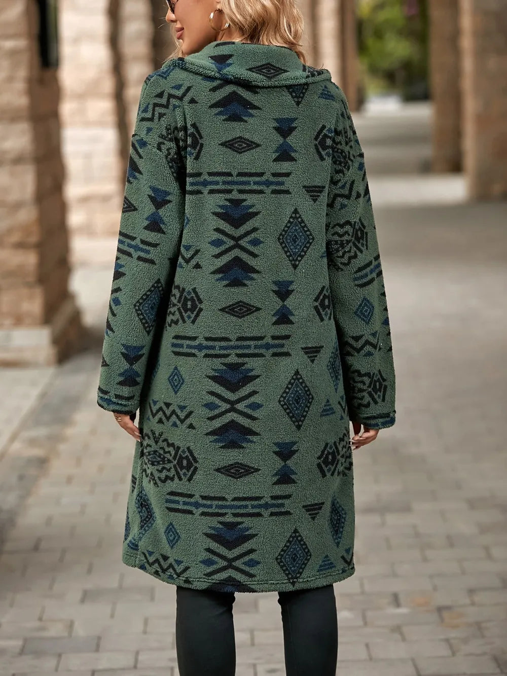 Person wearing a green patterned coat on a street.