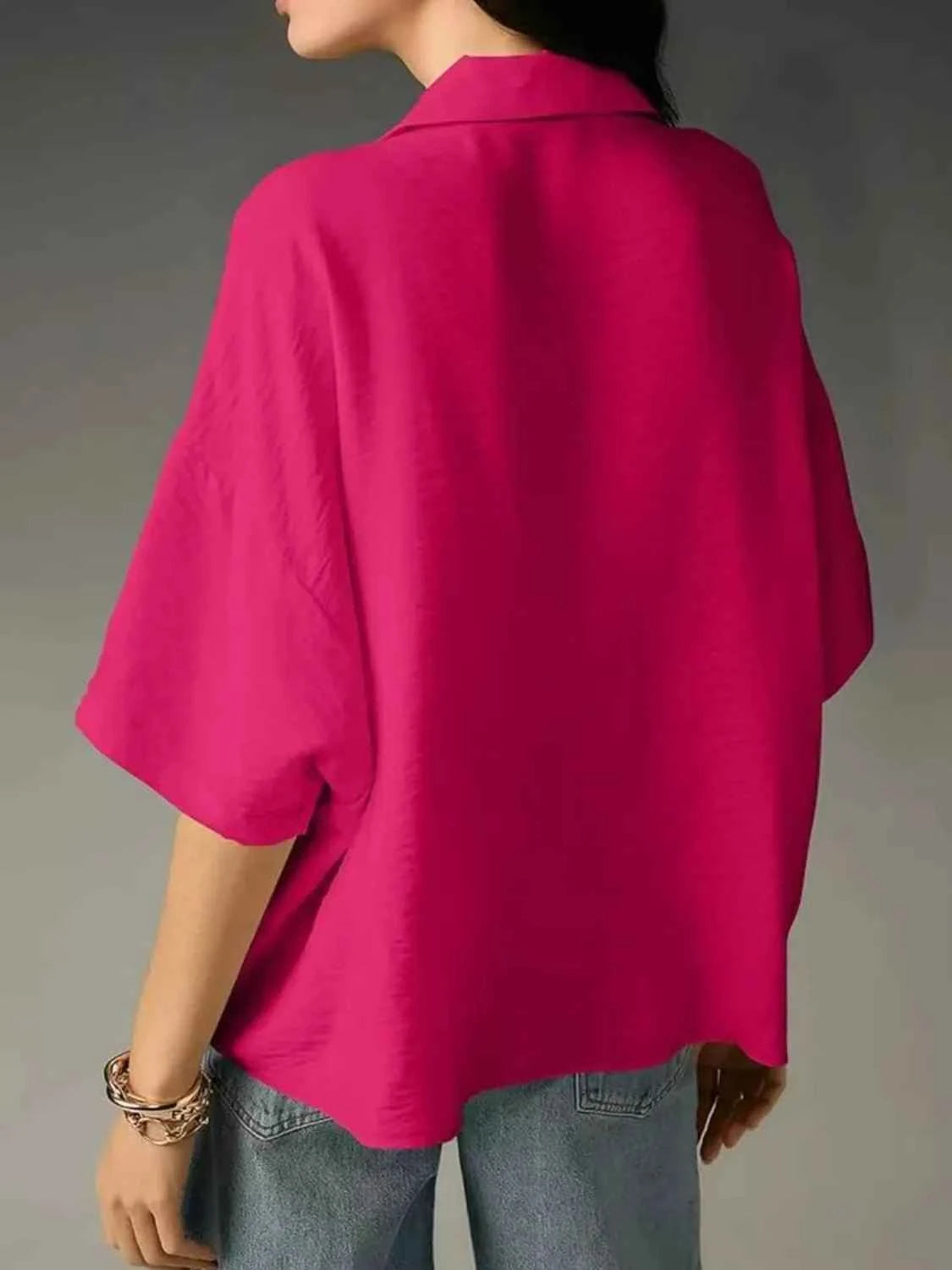Person wearing a bright pink shirt with a gray background