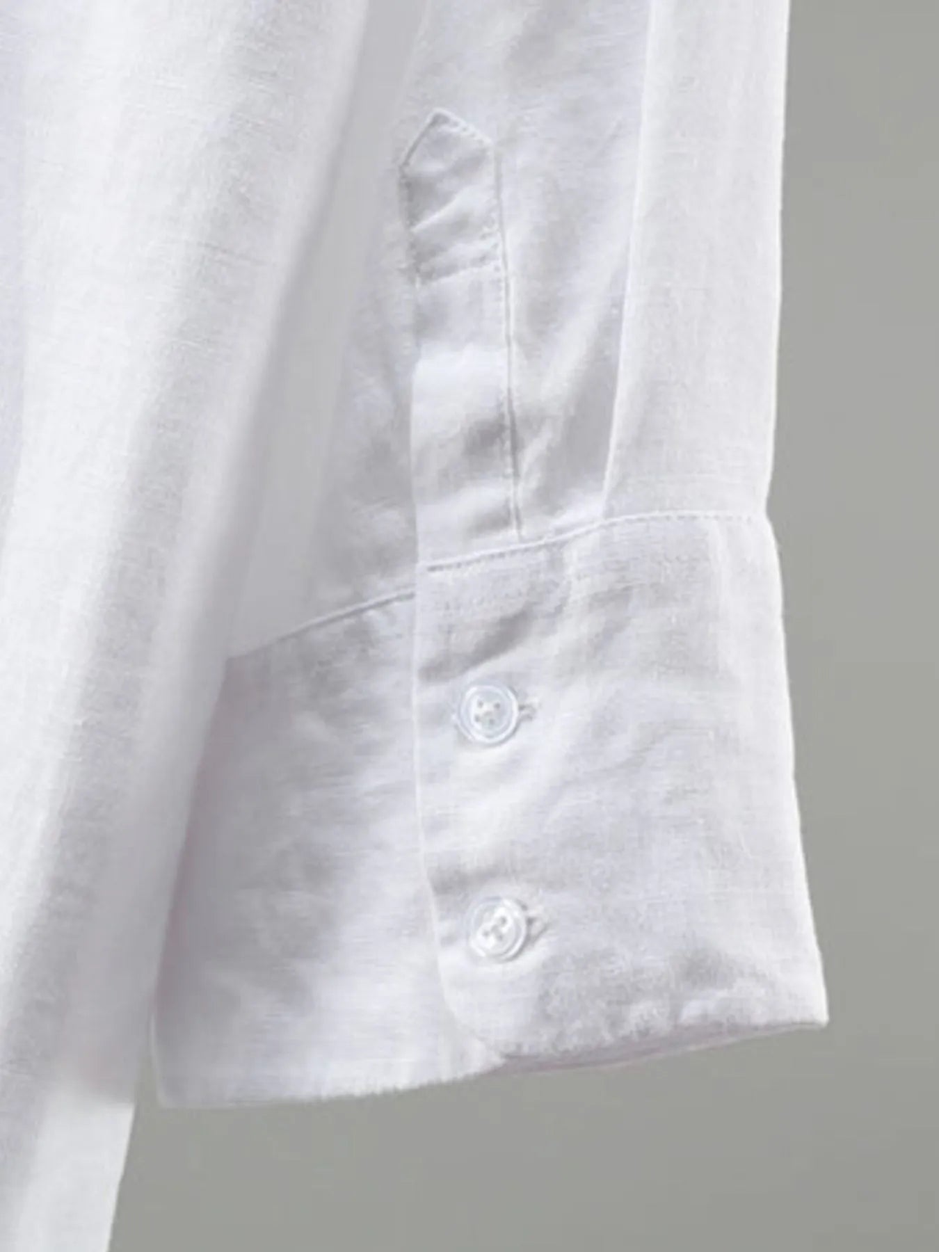 Close-up of a white shirt with buttons on a gray background