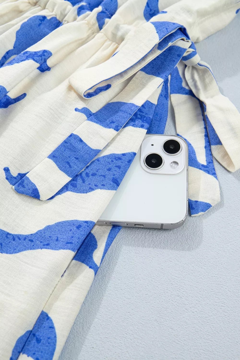 Phone case with blue and white pattern on a fabric background