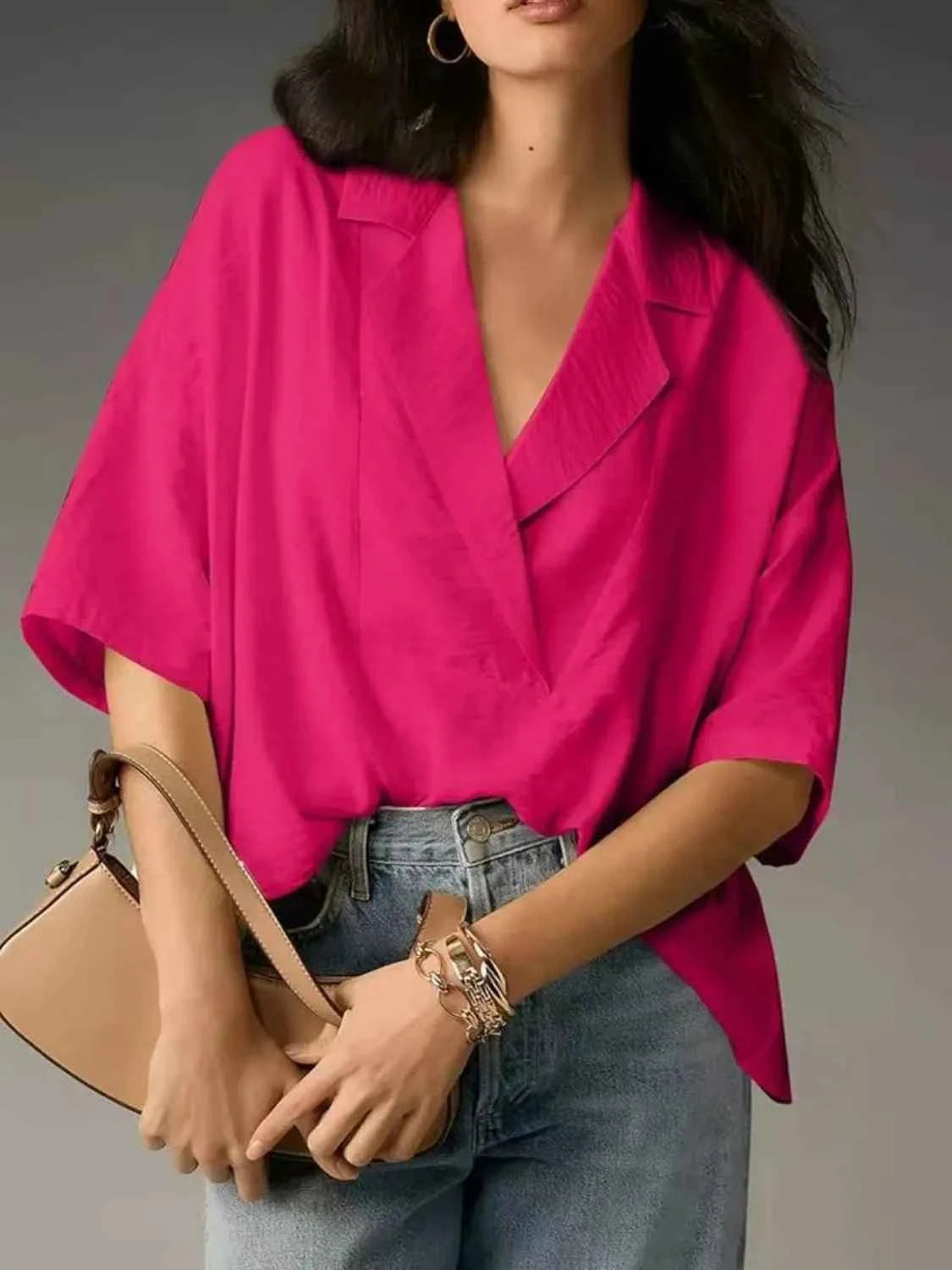 Person wearing a bright pink blouse with a neutral background