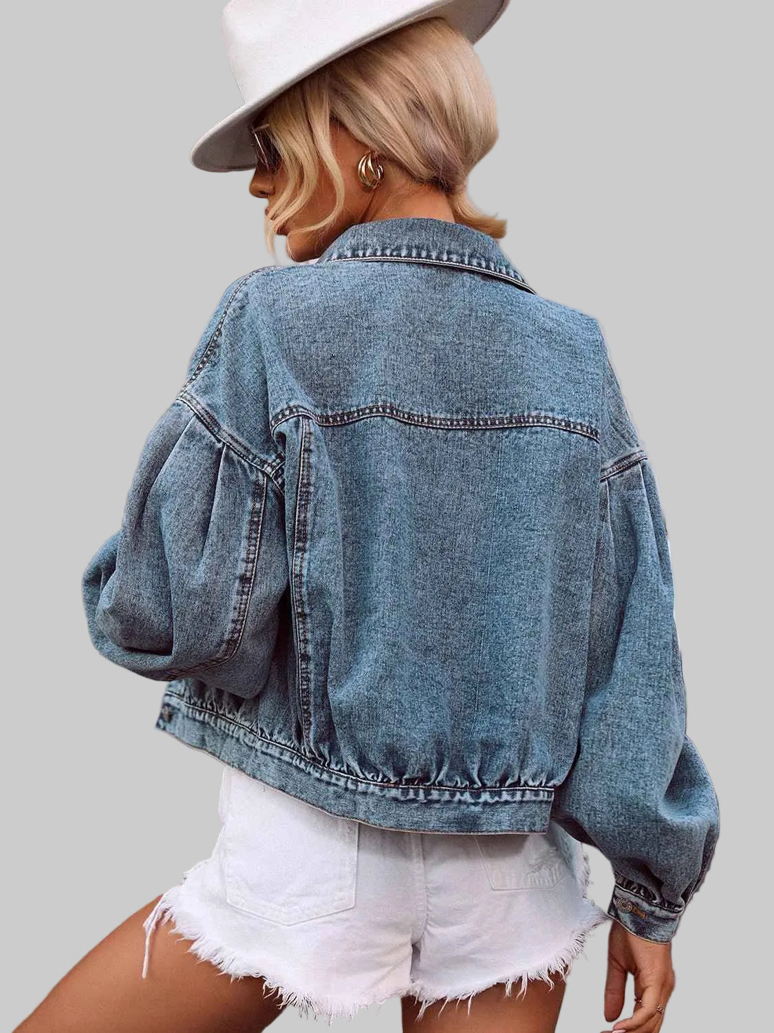 Person wearing a denim jacket and white shorts outdoors