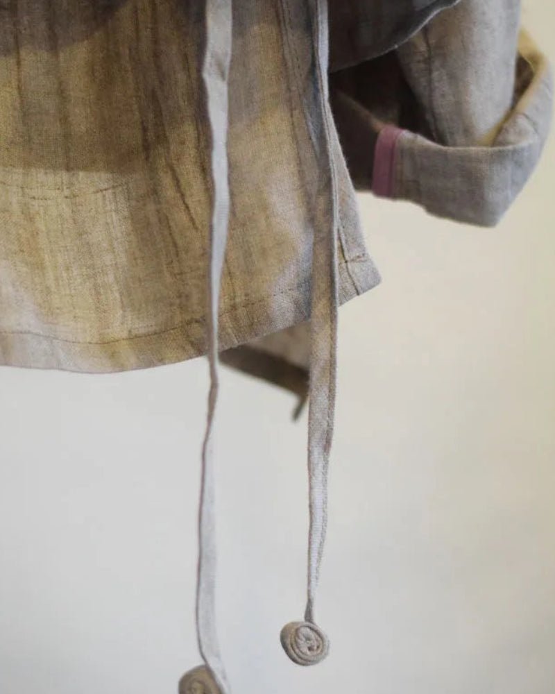 Close-up of a plaid shirt with a button on a white background