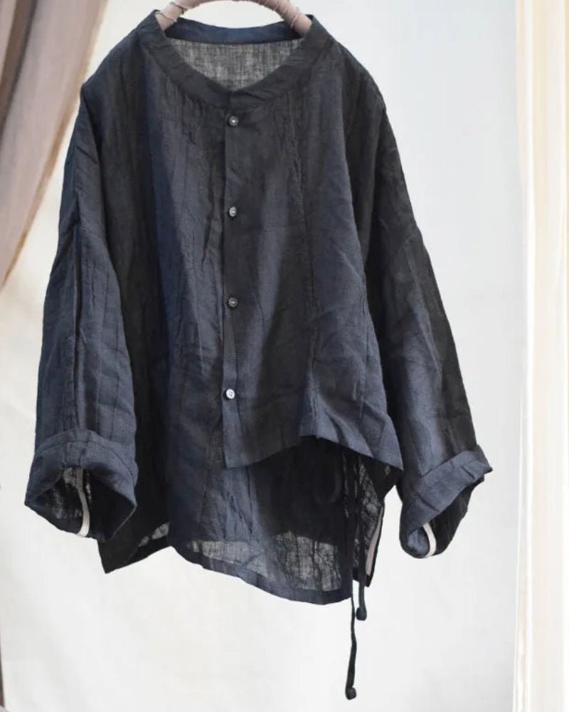 Dark gray shirt on a hanger against a white background