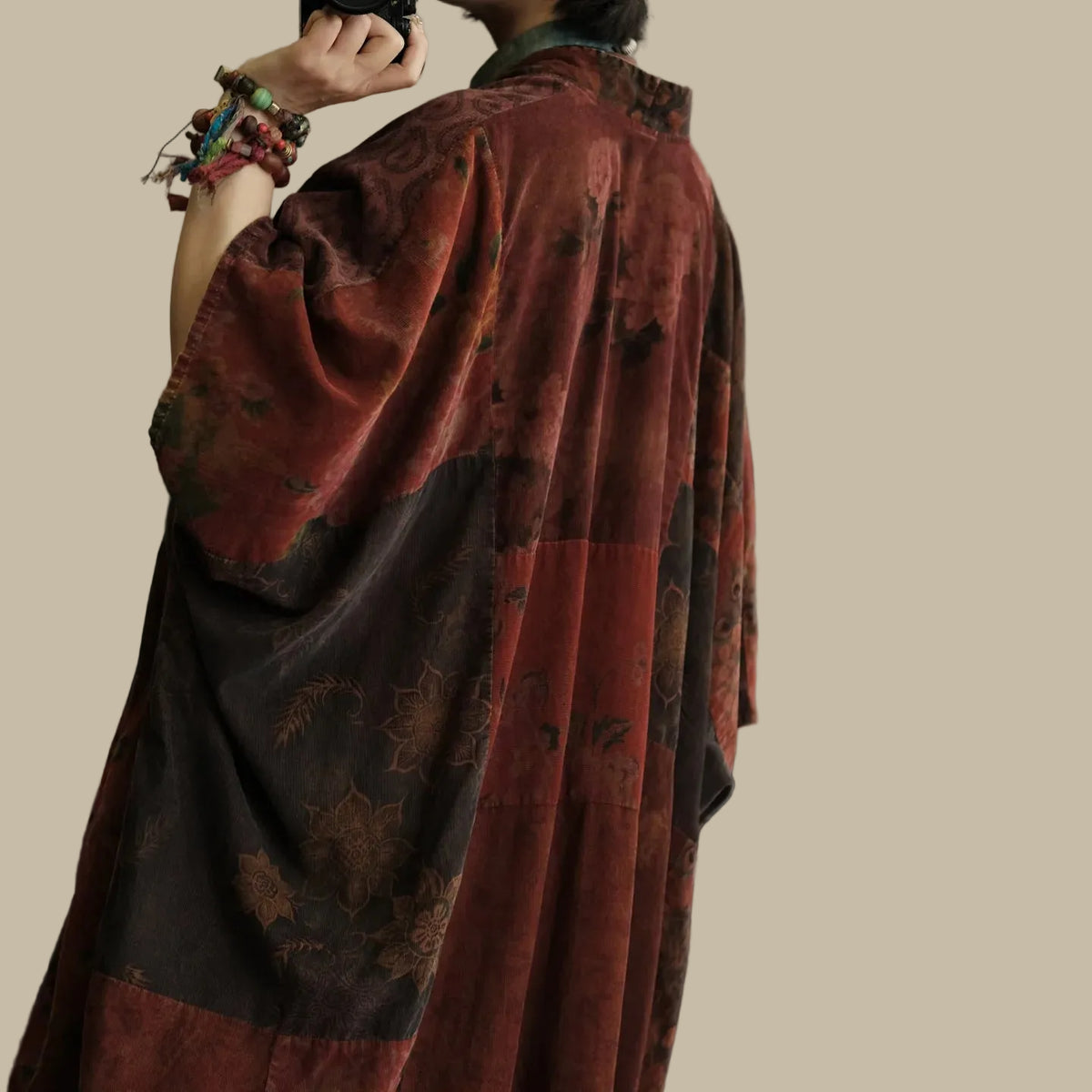 Person wearing a patterned red garment in a softly blurred indoor setting