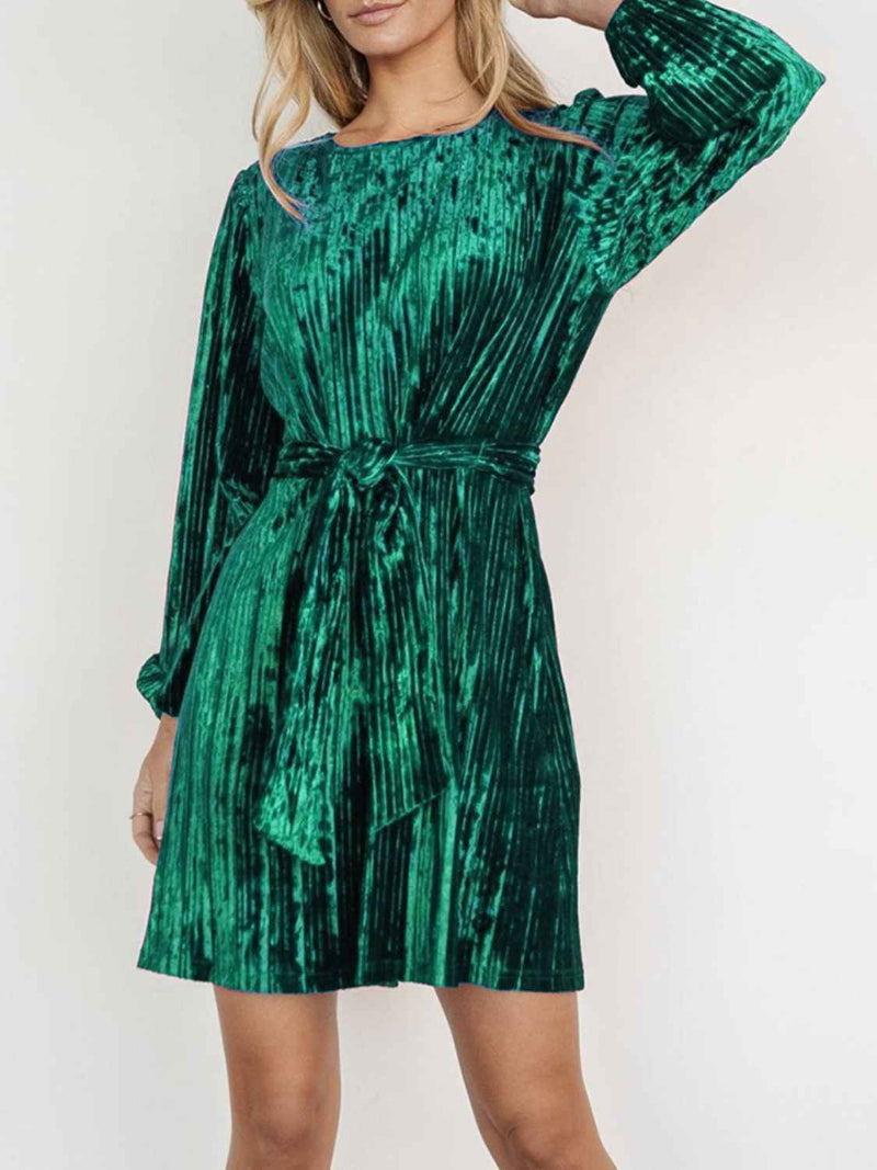 Green patterned dress worn by a person on a white background