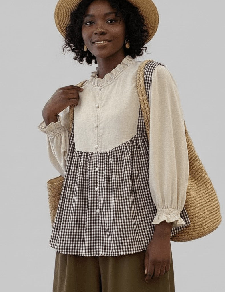 Woman wearing a checkered dress over a white blouse with a straw hat and bag on a plain background