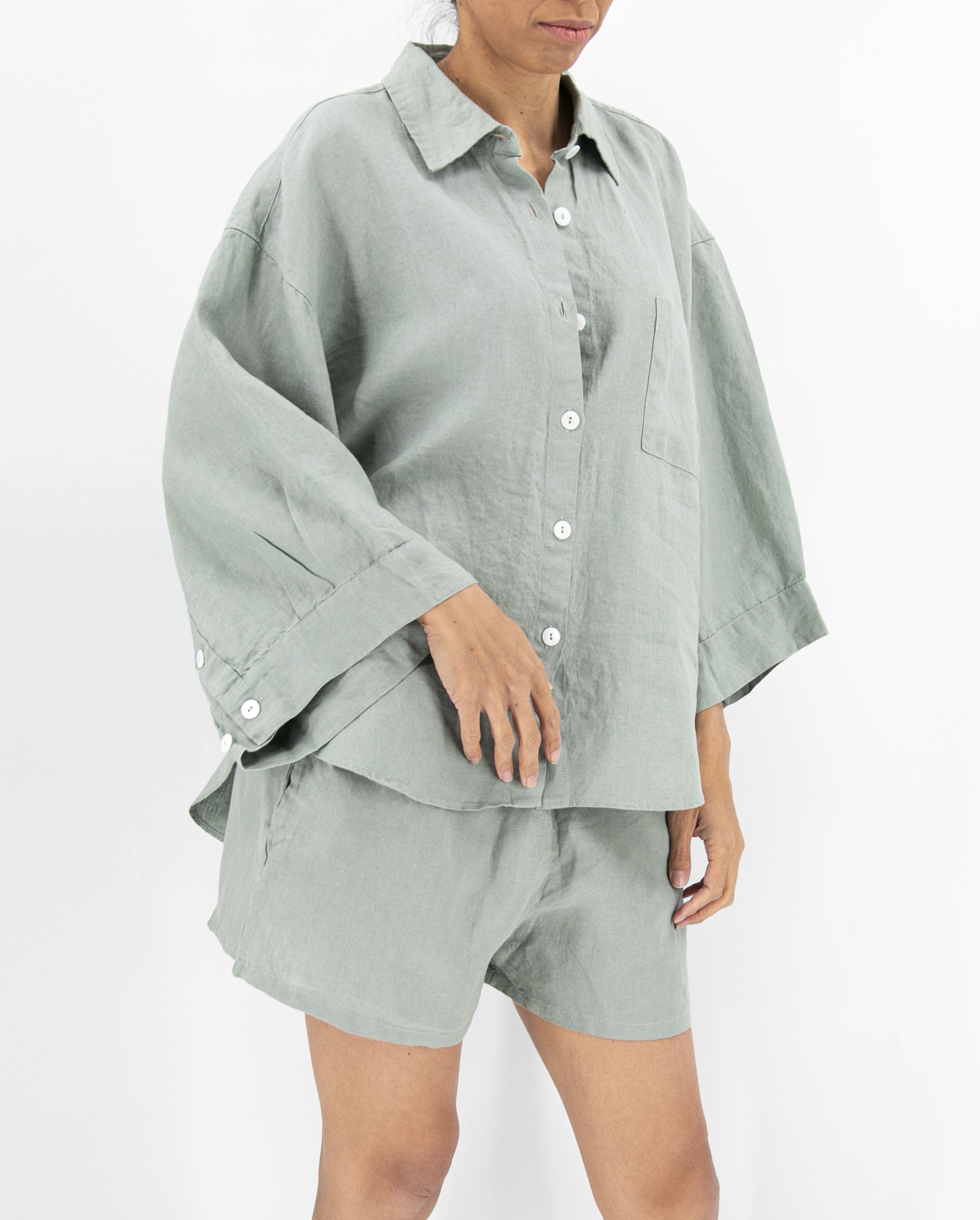 Person wearing a light green shirt and shorts set on a white background