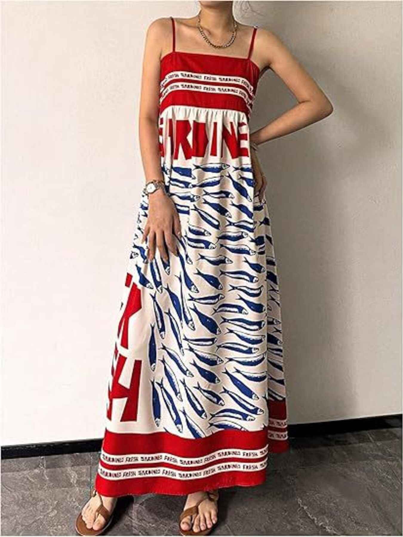 Person wearing a long dress with red, white, and blue pattern against a plain background