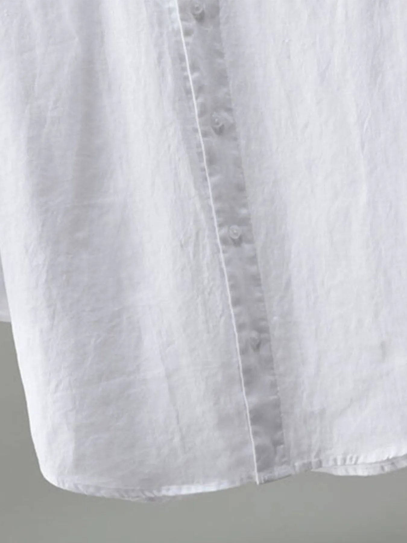 Close-up of a white shirt with a gray background