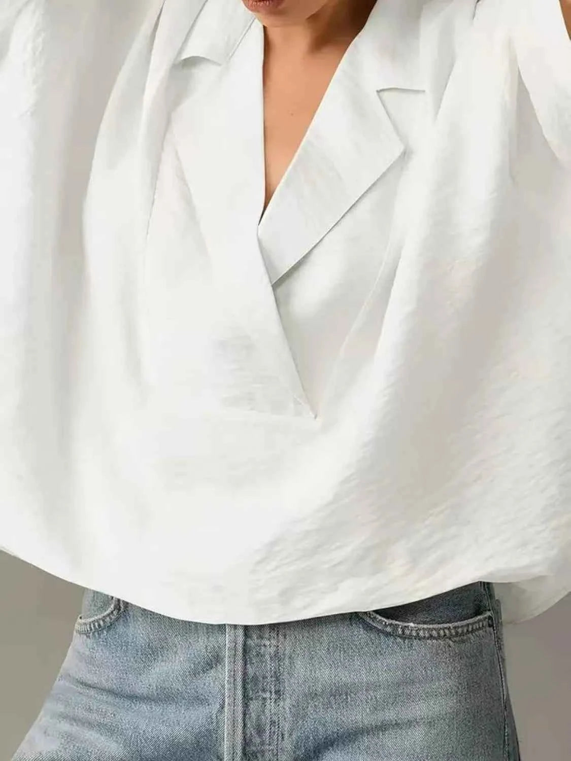 White blouse worn over a plain background