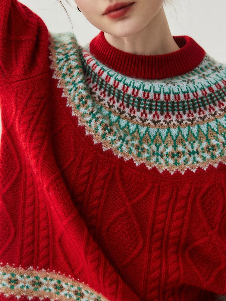 A close-up of a red cable-knit sweater with a multicolor Fair Isle yoke pattern in green, beige, and white, worn by a model.