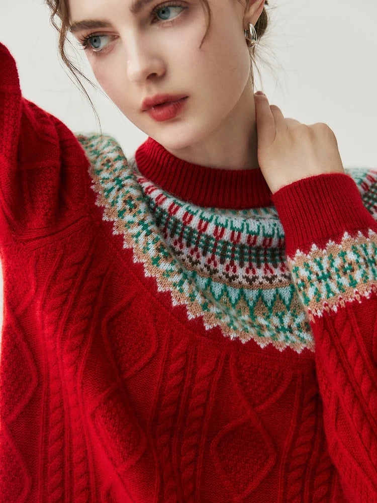 A close-up of a woman wearing a red cable-knit sweater with a multicolor Fair Isle yoke pattern in green, white, and red.