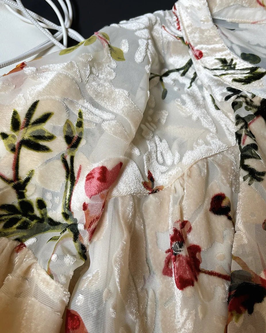 Floral patterned fabric with red flowers and green leaves on a white background