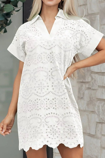 White lace dress worn by a model against a stone wall background