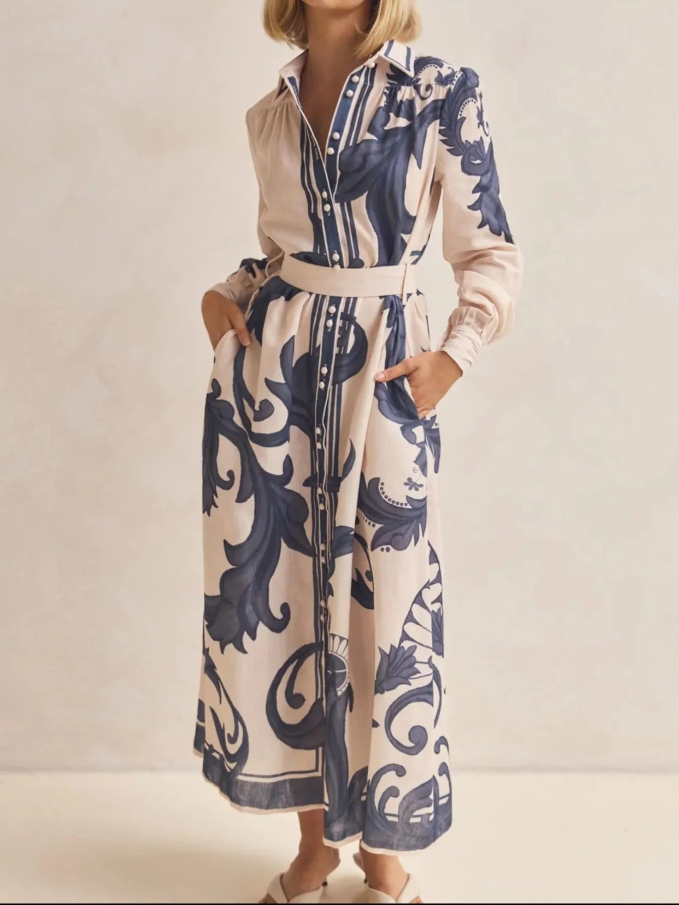Woman wearing a long floral dress with a neutral background