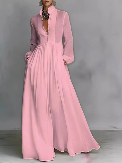 A_model_posing_in_a_vibrant_pink_long-sleeve_button-front_maxi_dress_featuring_a_V-neckline_Victorian-inspired_sleeves_and_a_relaxed_flowy_silhouette.