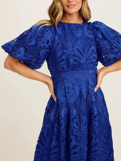 Blue lace dress worn by a model on a plain background