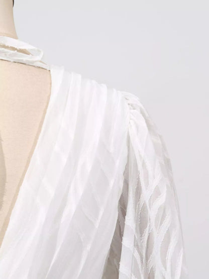 White dress with a sheer overlay on a mannequin against a light gray background
