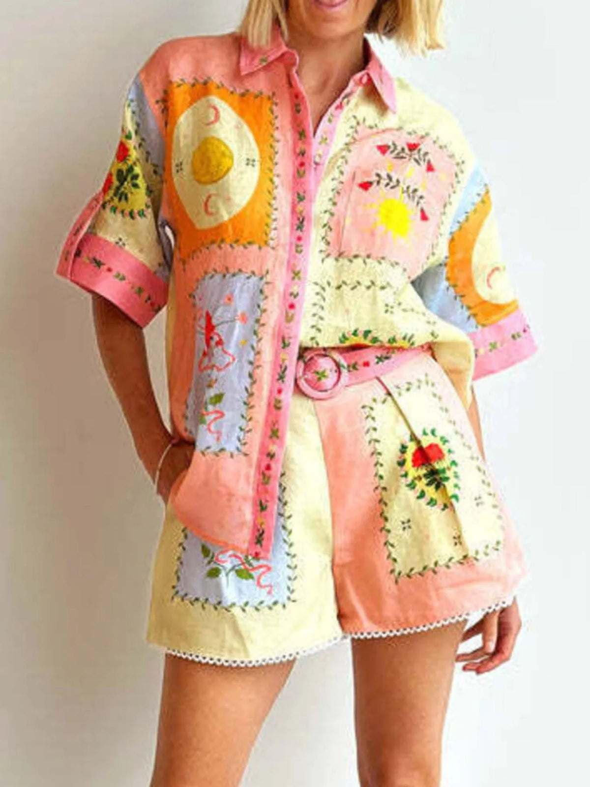 Person wearing a colorful patchwork outfit with a patterned shirt and shorts on a plain background