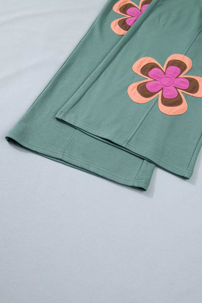 Green fabric with pink and orange floral patterns on a light gray background