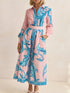 Woman wearing a pink and blue patterned dress on a beige background