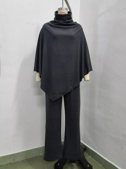 A dark charcoal gray two-piece set consisting of a draped turtleneck poncho top and matching wide-leg pants, displayed on a dress form mannequin against a plain white wall.