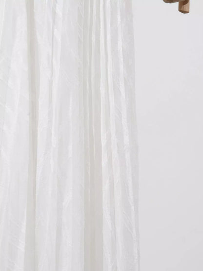 Close-up of white fabric with a subtle pattern on a light background