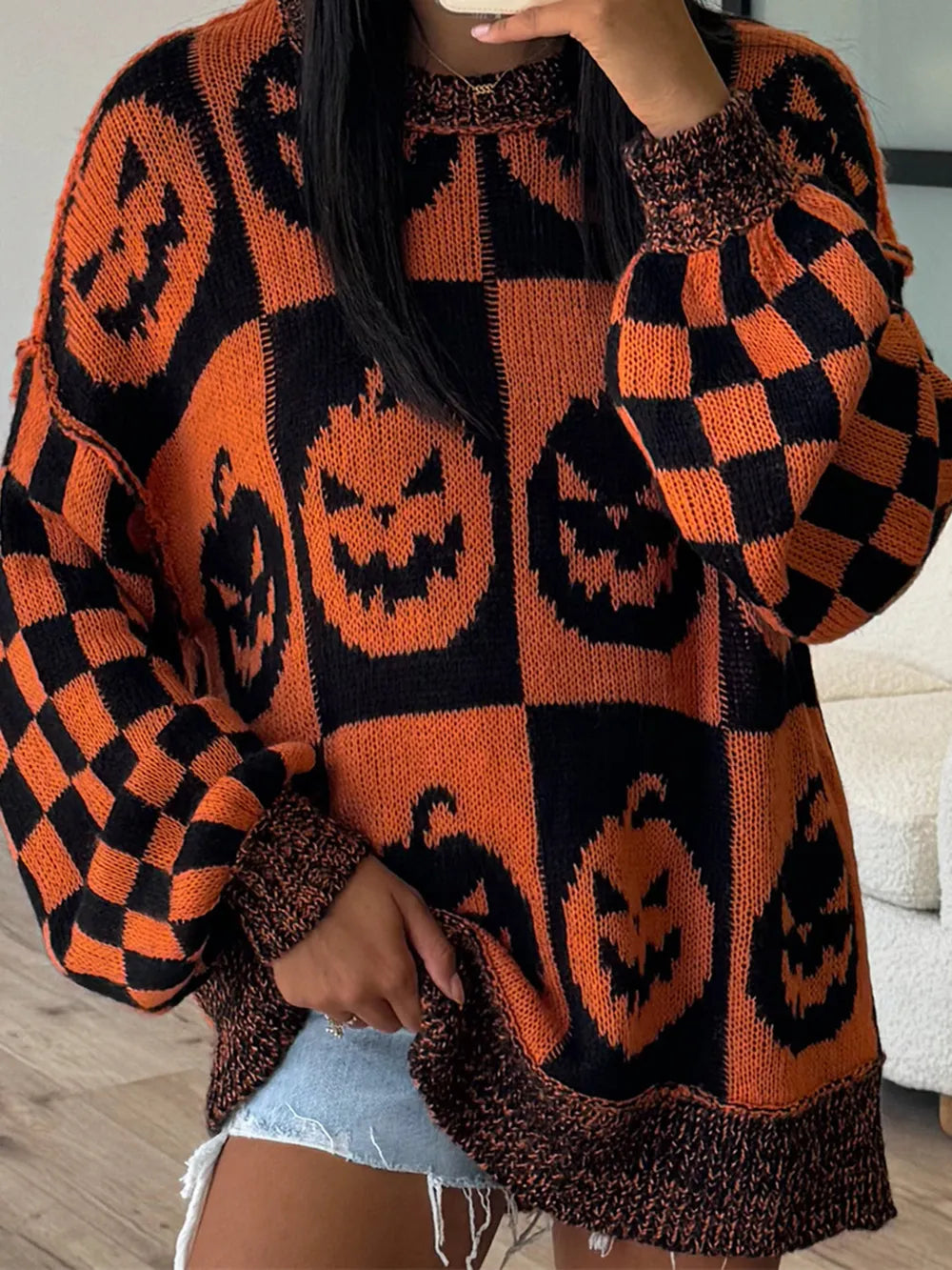 Person wearing a Halloween-themed sweater with jack-o&