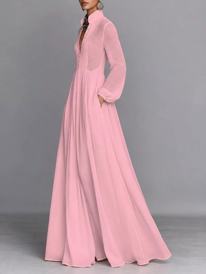 A_model_posing_in_a_vibrant_pink_long-sleeve_button-front_maxi_dress_featuring_a_V-neckline_Victorian-inspired_sleeves_and_a_relaxed_flowy_silhouette.