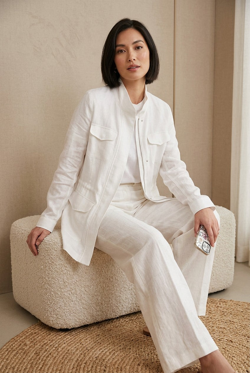 Woman wearing "The Florence Multi Pockets Pure Linen Jacket" and matching white linen trousers against a neutral studio background.