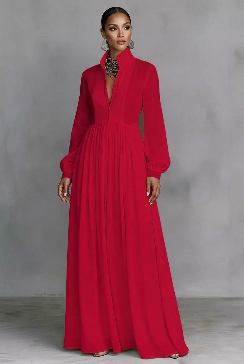 A_woman_wearing_a_red_long-sleeve_maxi_dress_with_a_deep_V-neckline_sheer_upper_chest_panel_and_side_pockets_standing_against_a_textured_gray_studio_backdrop.