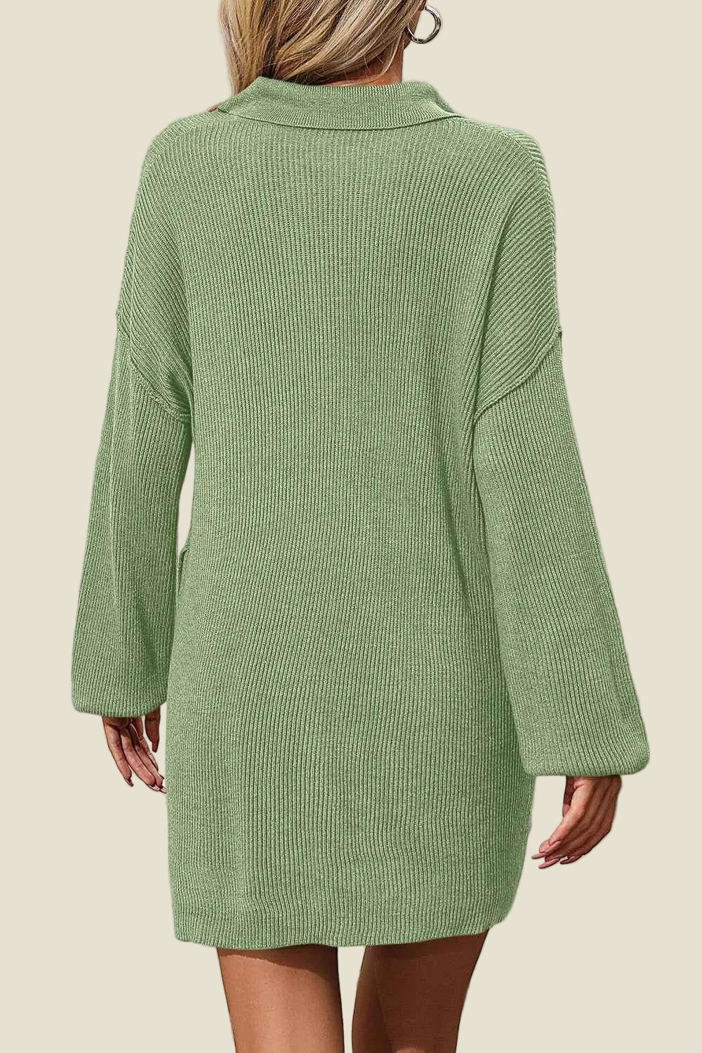 Green ribbed sweater dress worn by a person on a beige background