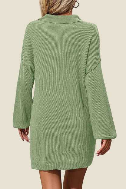 Green ribbed sweater dress worn by a person on a beige background