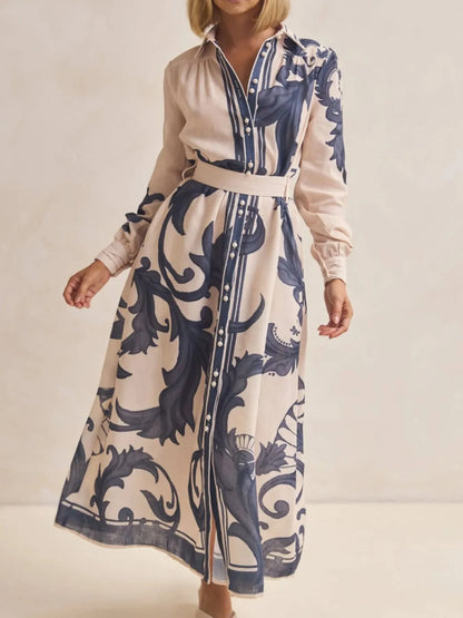 Woman wearing a long dress with blue floral pattern on a plain background