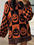 A person wearing an oversized knit sweater with a Halloween theme, featuring orange and black checkerboard patterns and large pumpkin faces.