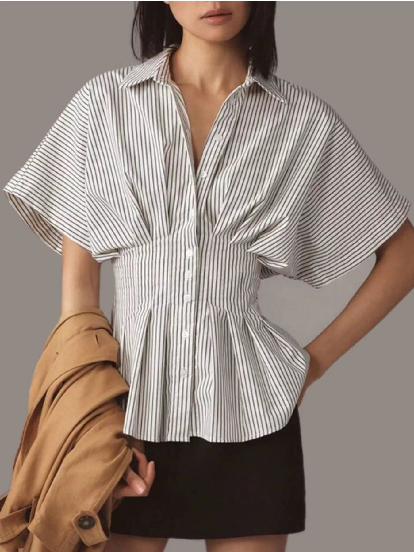 Woman wearing a black and white striped shirt with a plain background