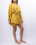 Person wearing a mustard yellow outfit on a white background