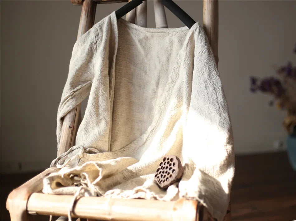 Beige towel draped over a wooden chair with a blurred background
