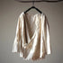 Beige linen shirt on a hanger against a plain background