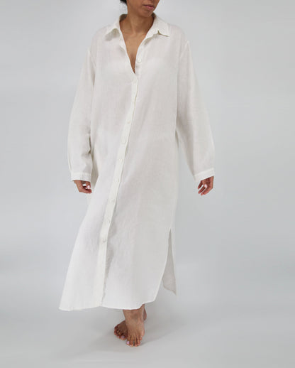 Person wearing a long white shirt on a plain background