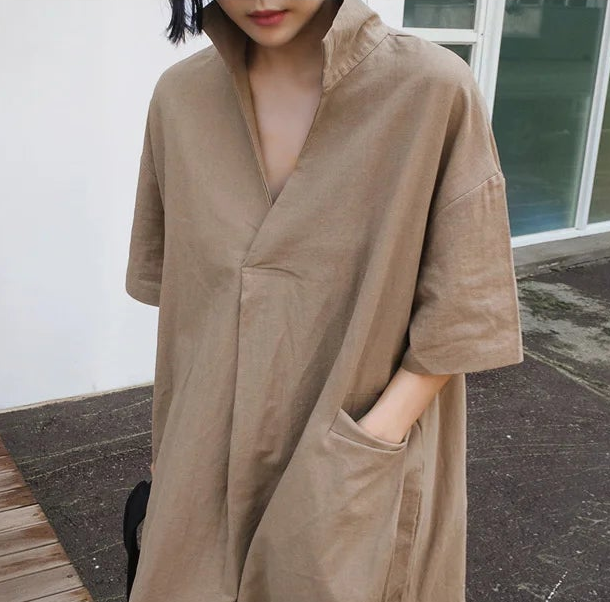 Person wearing a beige trench coat outdoors.
