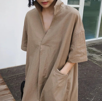 Person wearing a beige trench coat outdoors.