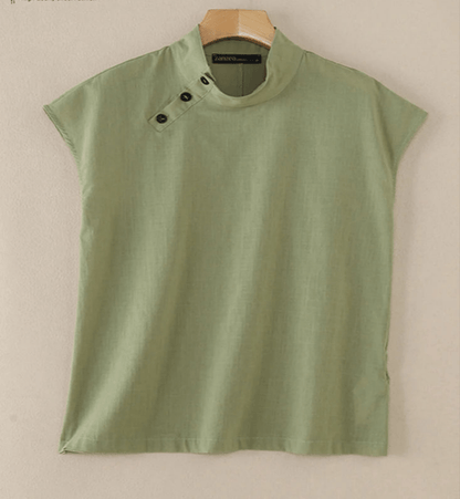 Green blouse with black buttons on a beige background