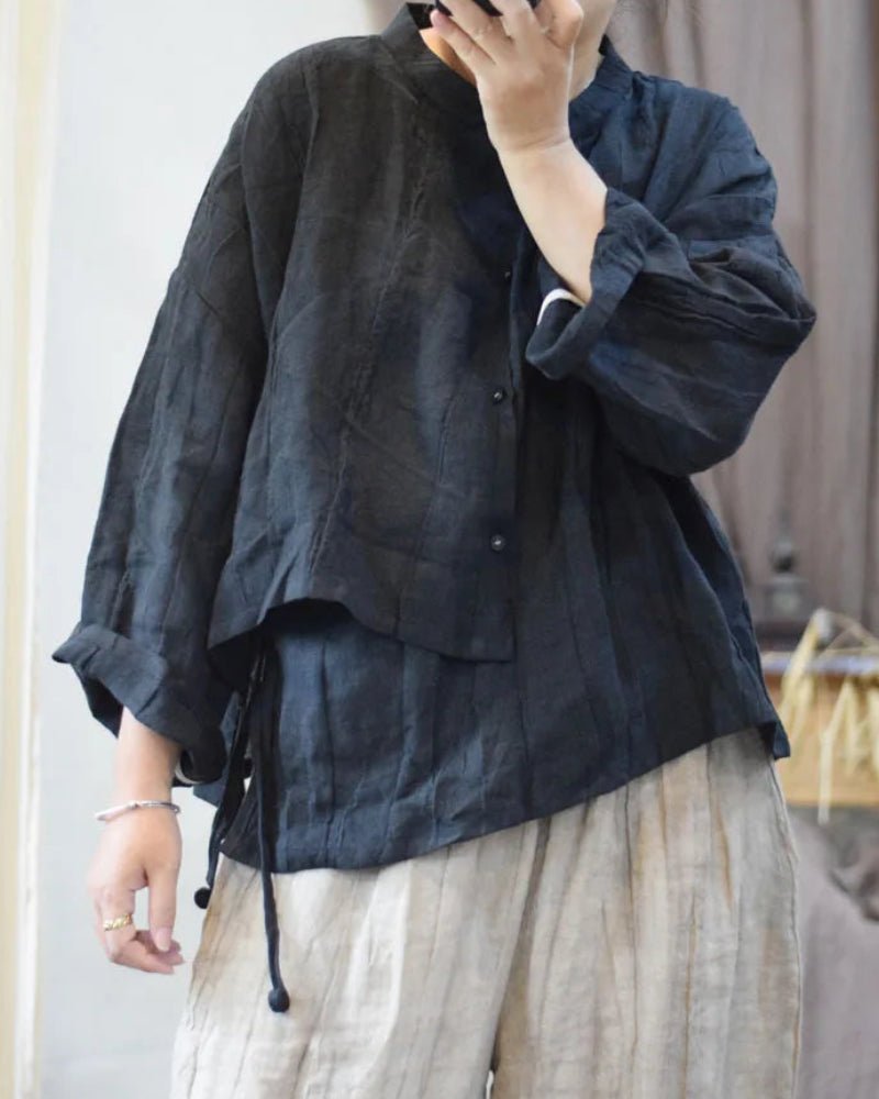 Person wearing a dark textured shirt and light pants indoors