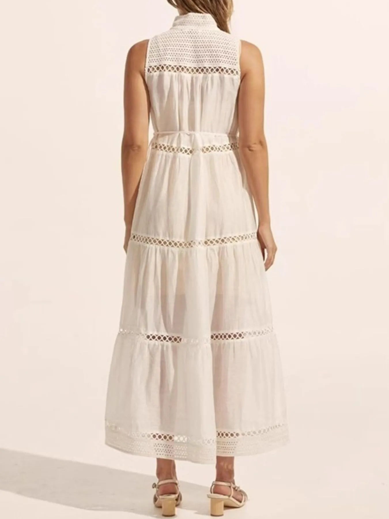 White sleeveless dress with lace details on a white background