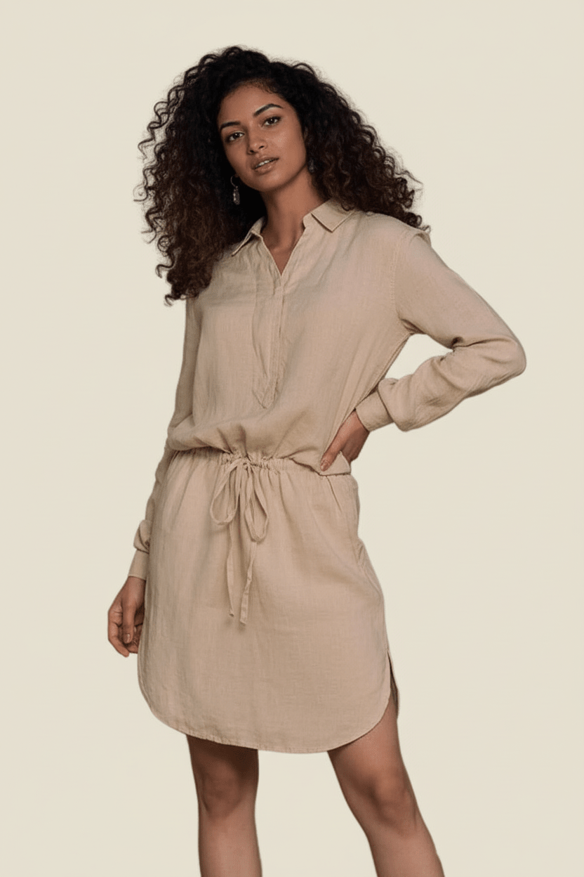 Woman wearing a beige shirt dress against a plain background