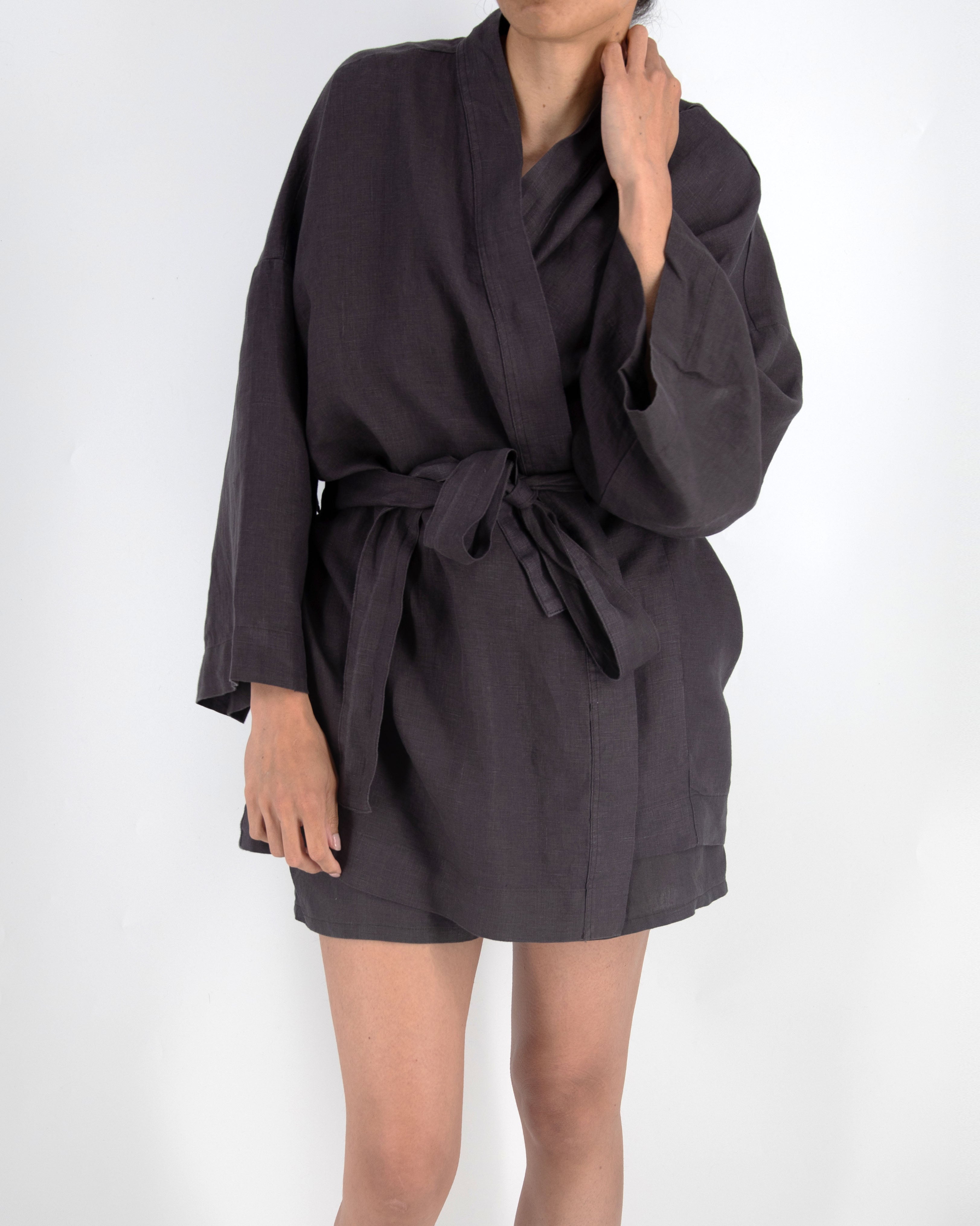 Person wearing a dark gray robe on a white background