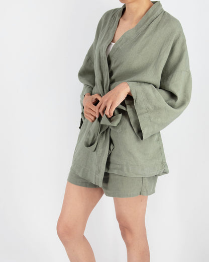 Person wearing a green robe and shorts on a white background