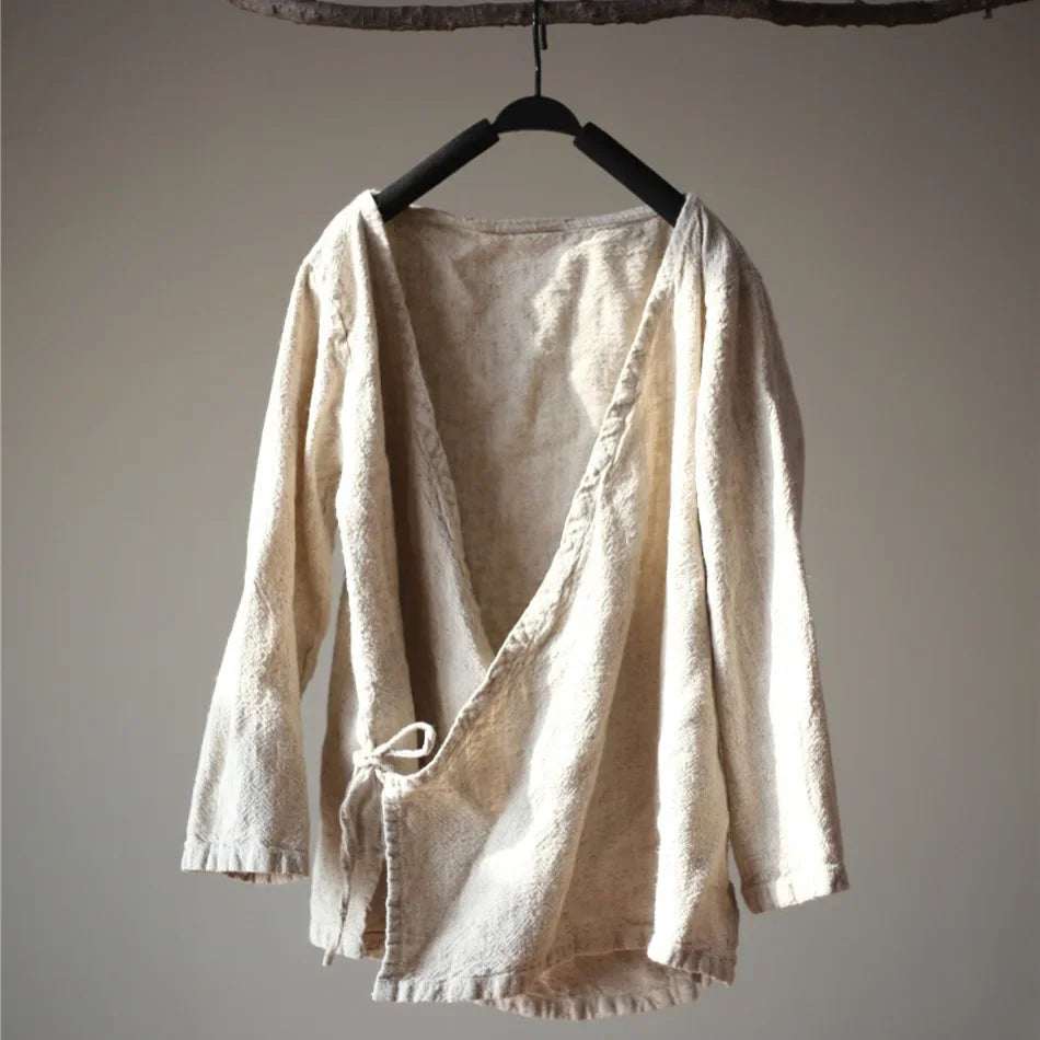 Beige linen shirt on a hanger against a plain background